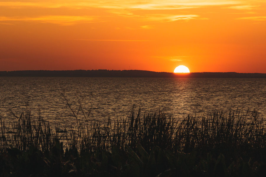 Sunset over distant hills on Lake Apopka in Apopka, Florida. Photo credit ShutterStock.com, licensed.