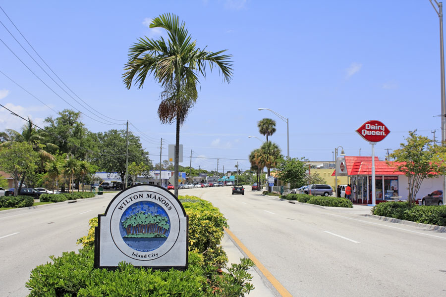 Sign that says Wilton Manors and Island City with palm trees on an island graphic in the median of Wilton Drive in this urban city of 12,630 in 2019. Wilton Manors, Florida, May 11, 2013. 