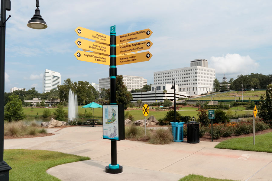 Four-way directional sign each point to 12 local locations. Sunny Cascades park near downtown Tallahassee, FL, July 15, 2018. 
